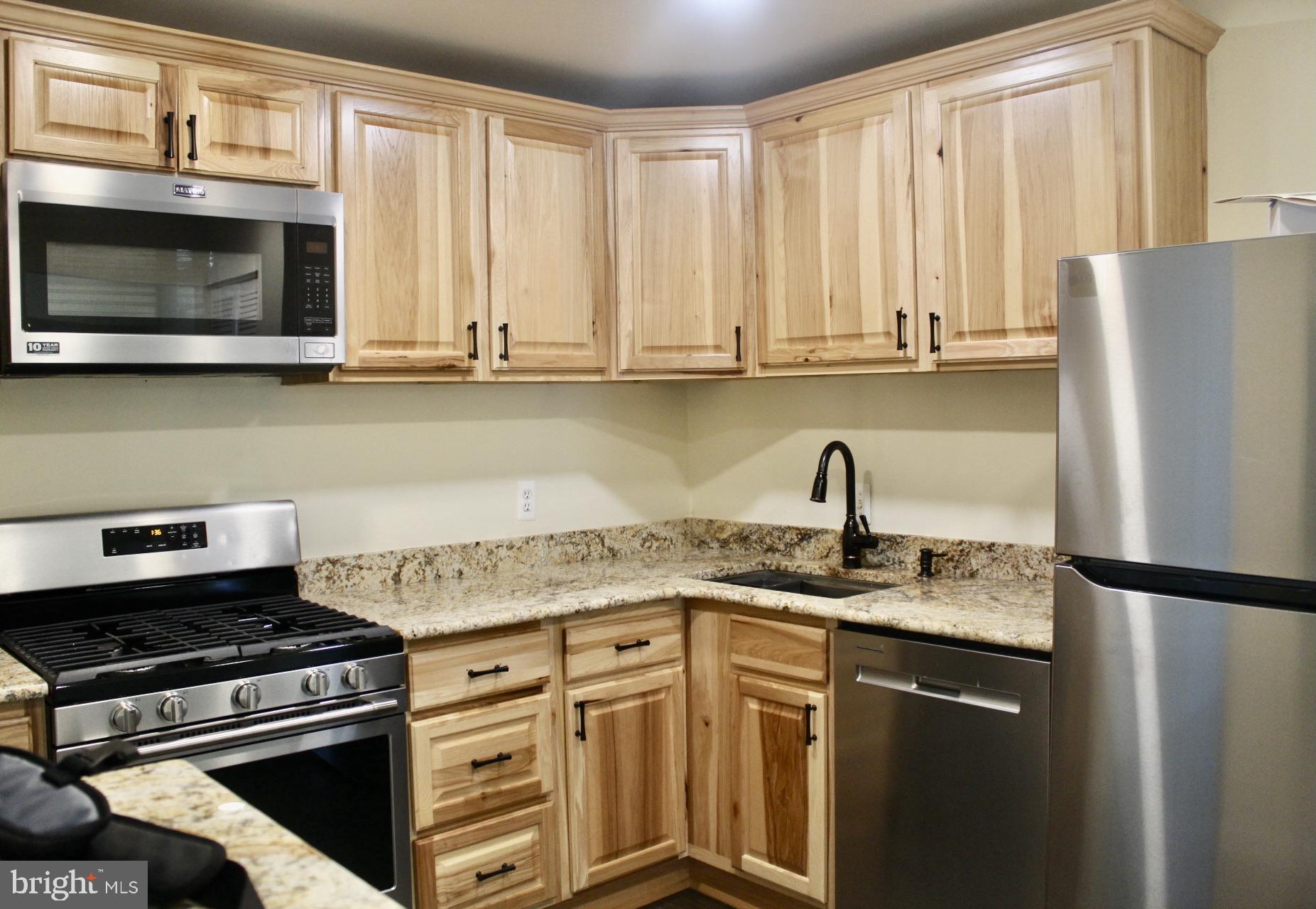 7904 Inverton Road, Unit 204 Annandale, VA 22003 - Photo 7 of 24 a kitchen with granite countertop a sink stove and microwave