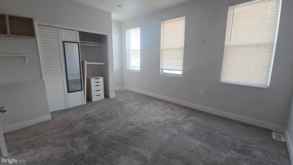 an empty room with windows and closet