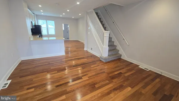 a view of an empty room with wooden floor