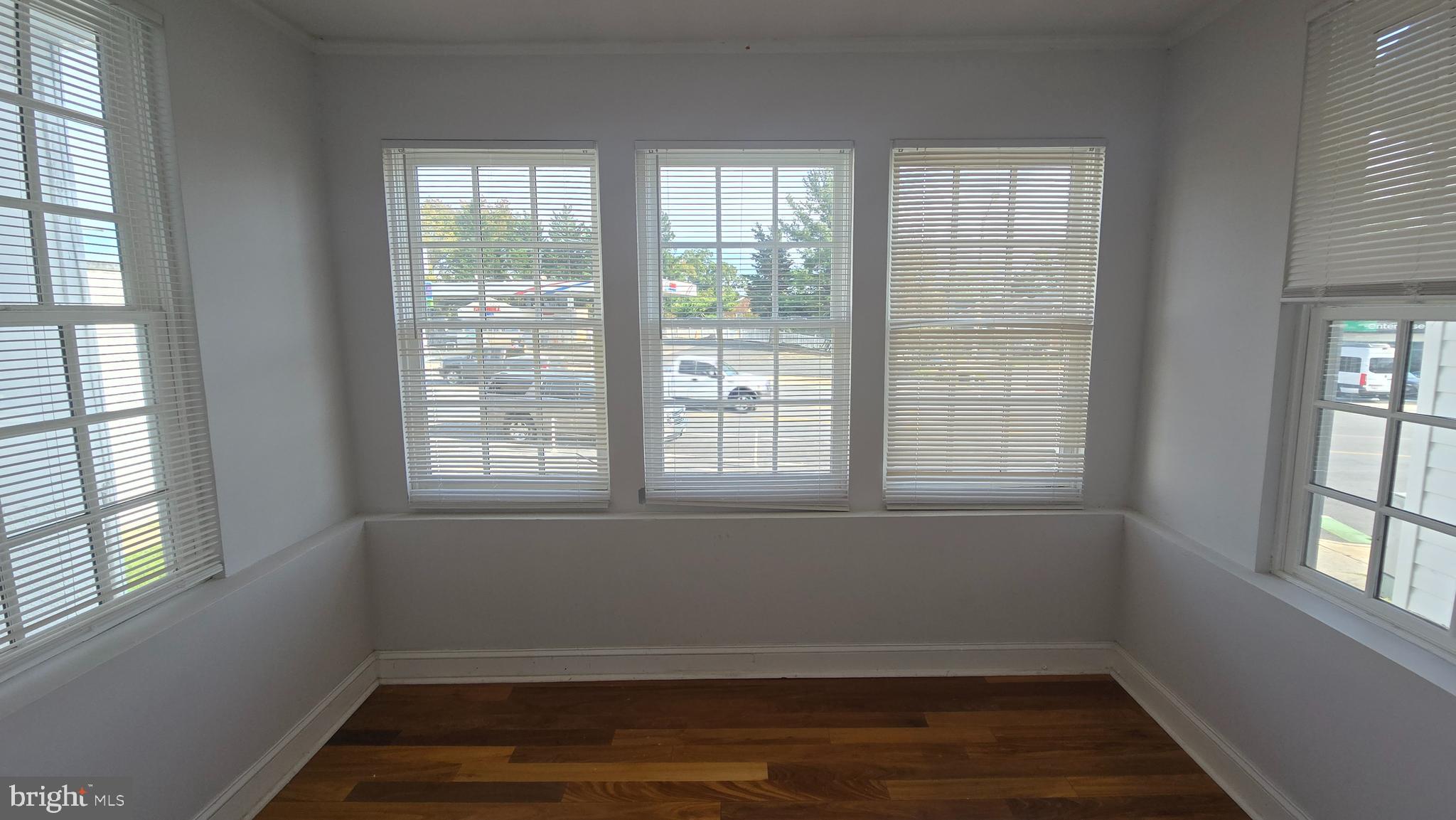 6814 Harford Road Baltimore, MD 21234 - Photo 6 of 27 an empty room with wooden floor and windows