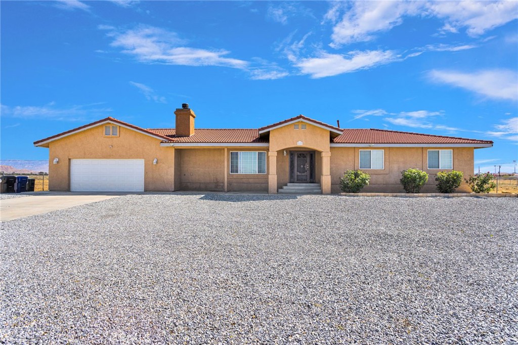 21237 S Road Apple Valley, CA 92307 - Photo 2 of 50 a front view of a house with a yard and potted plants