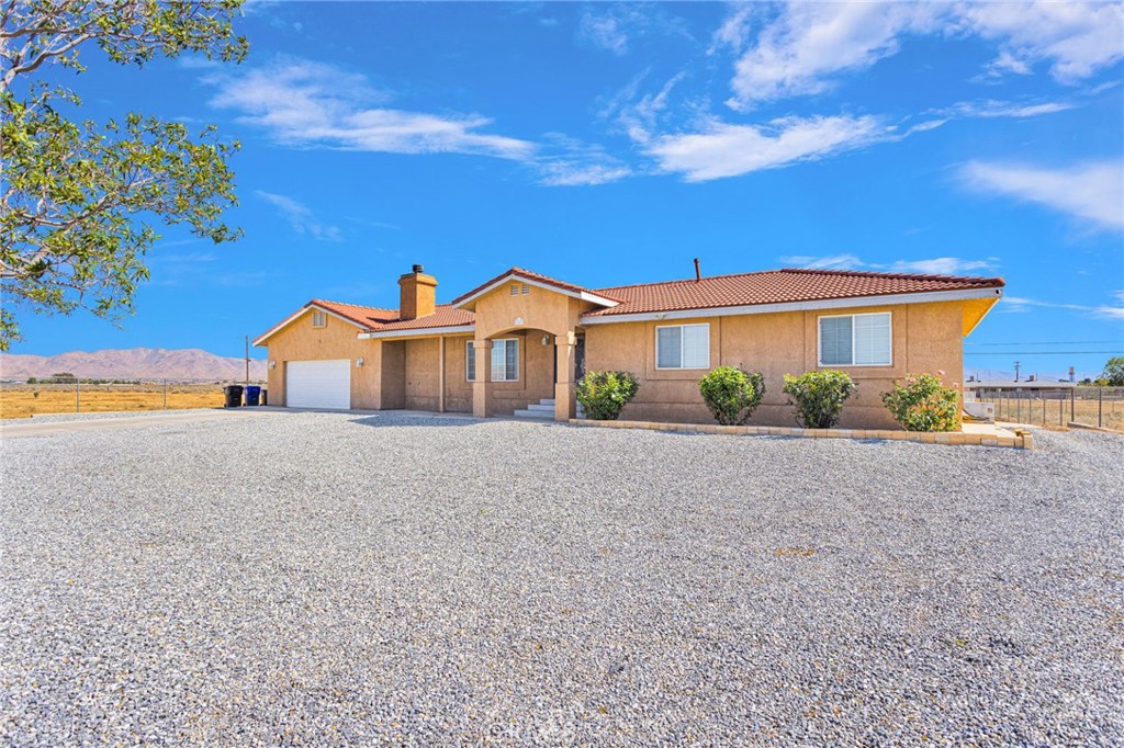 21237 S Road Apple Valley, CA 92307 - Photo 4 of 50 a front view of a house with a yard and garage