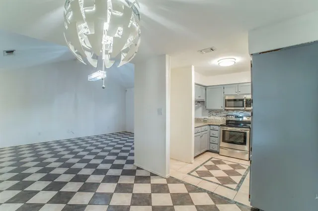 a view of a house with a yard and large tree