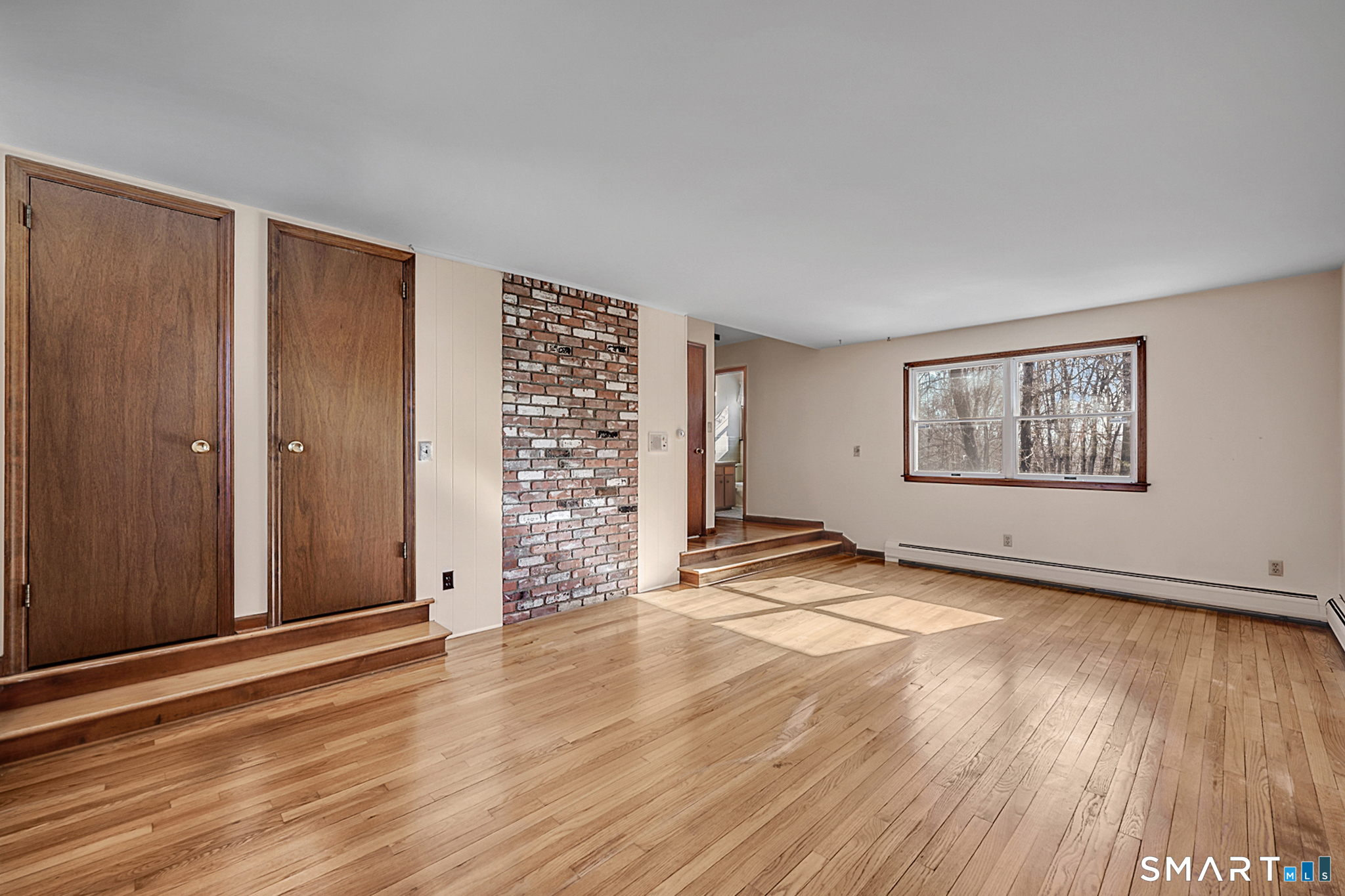 67 Hillside Lane Monroe, CT 06468 - Photo 15 of 40 This space features three closets, providing ample storage. The room is accentuated by exquisite brick detailing, adding a touch of rustic charm.