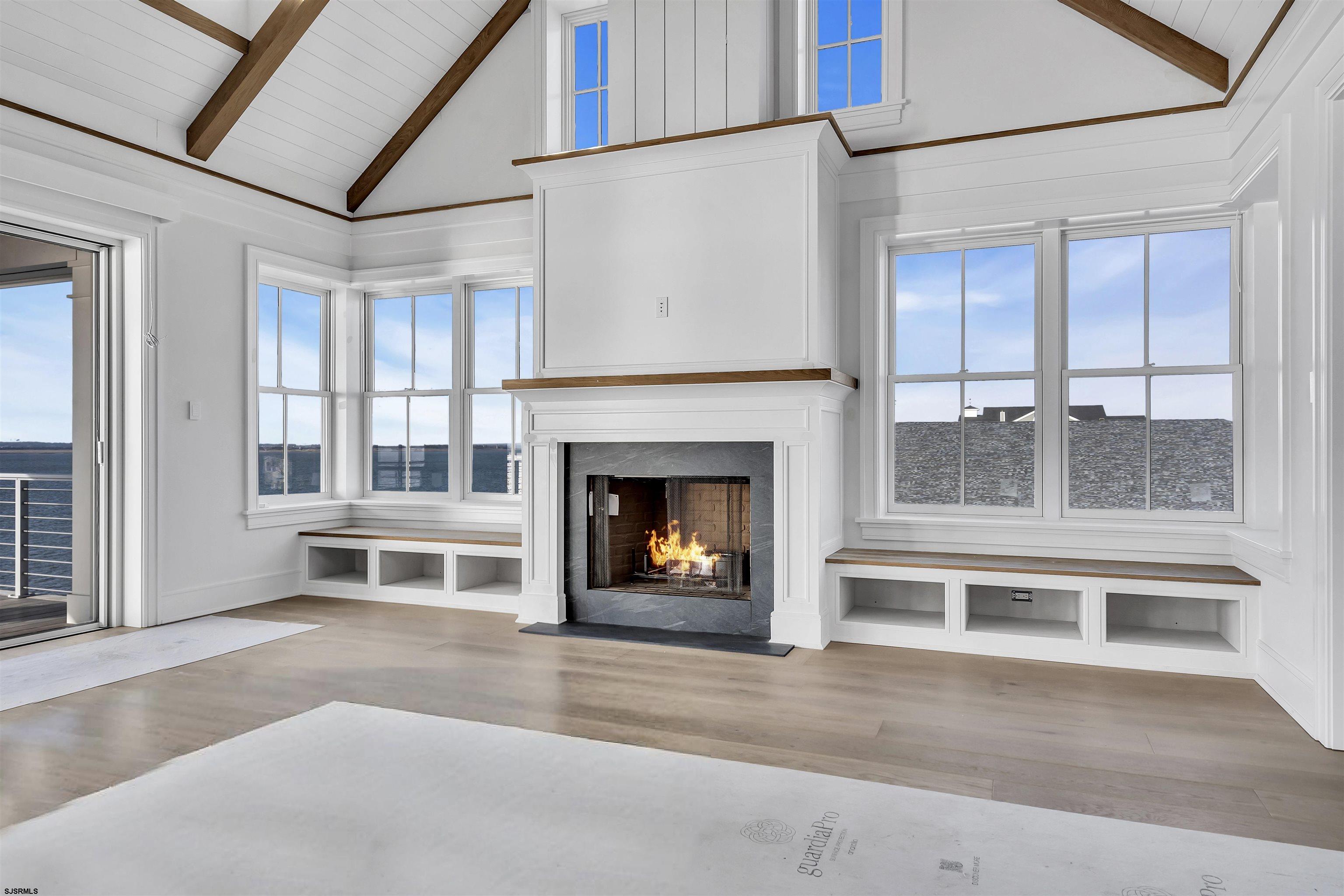 176-80 Bay Road Ocean City, NJ 08226 - Photo 5 of 58 a living room with a fireplace and a floor to ceiling window