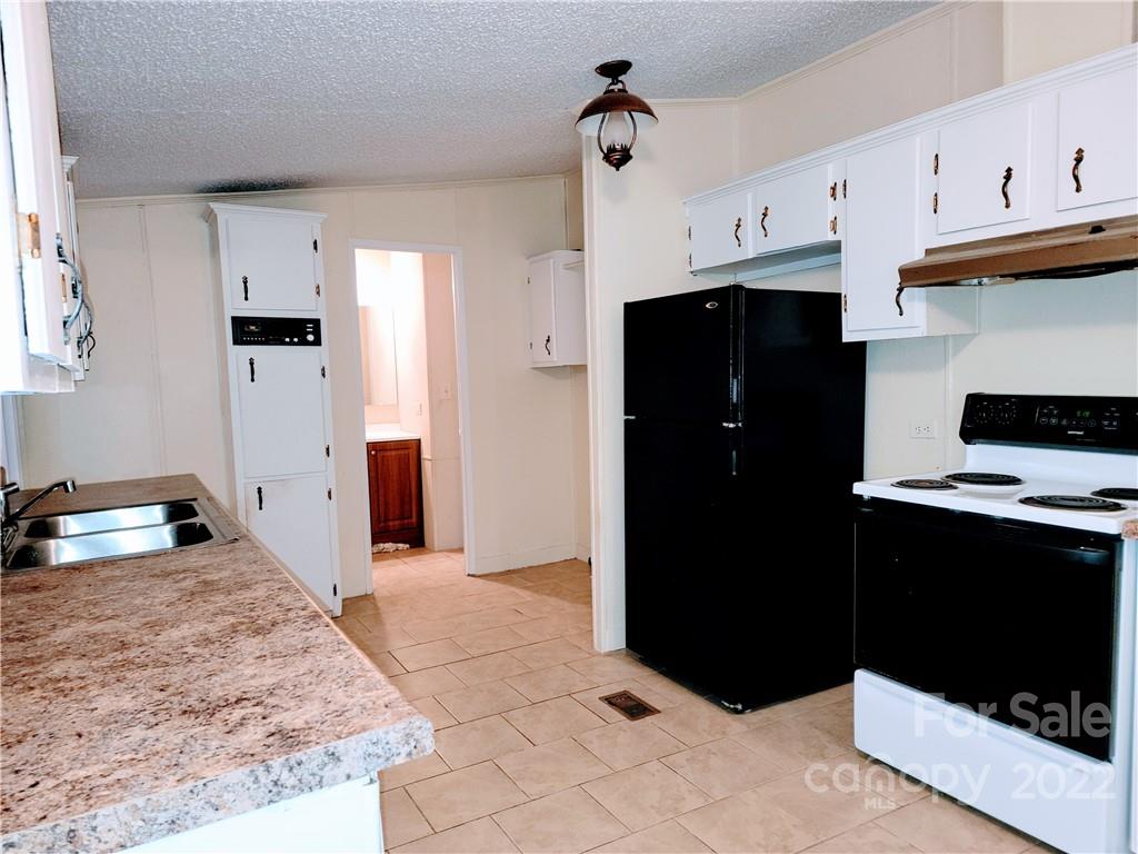 231 Bud Black Road Crouse, NC 28033 - Photo 8 of 18 a kitchen with stainless steel appliances kitchen island granite countertop a refrigerator and a stove
