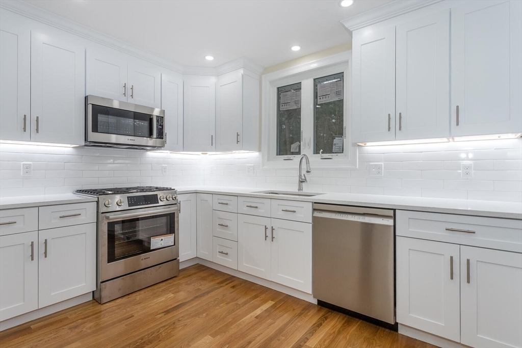 71 Morton Street Canton, MA 02021 - Photo 13 of 39 a kitchen with granite countertop white cabinets stainless steel appliances and sink