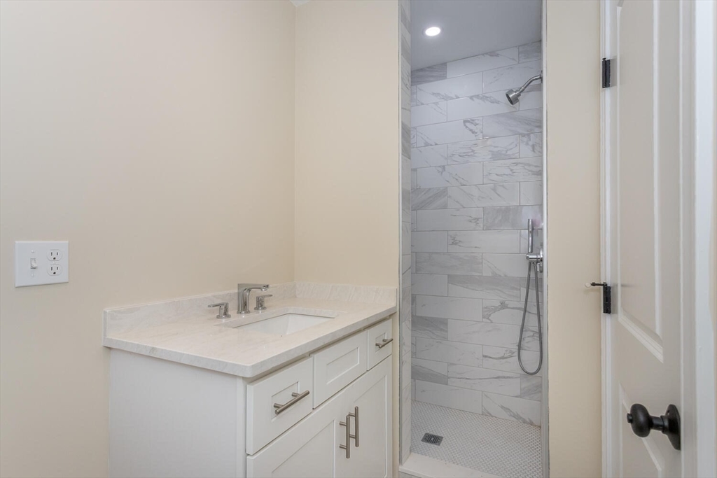 71 Morton Street Canton, MA 02021 - Photo 21 of 39 a bathroom with a shower sink vanity and a mirror