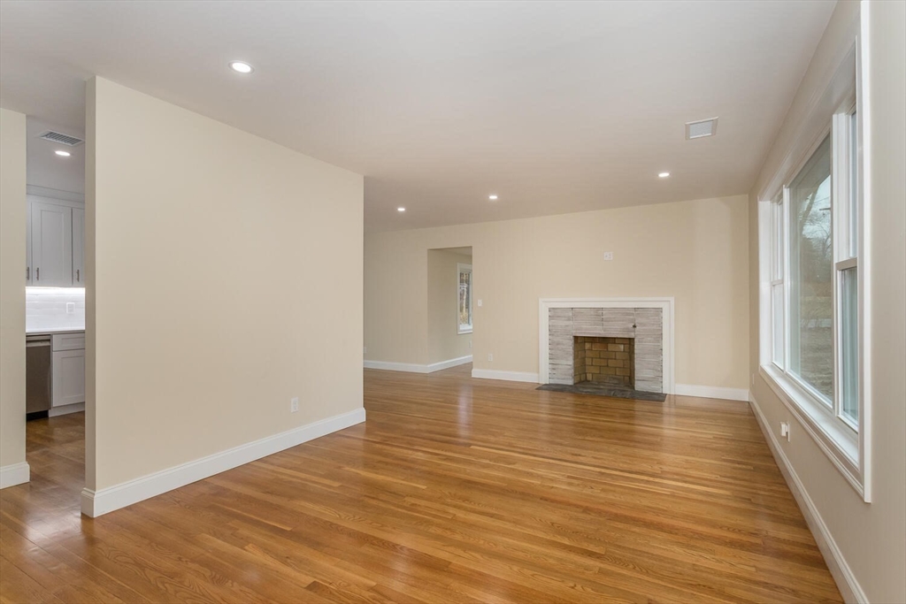 71 Morton Street Canton, MA 02021 - Photo 5 of 39 an empty room with wooden floor and fireplace
