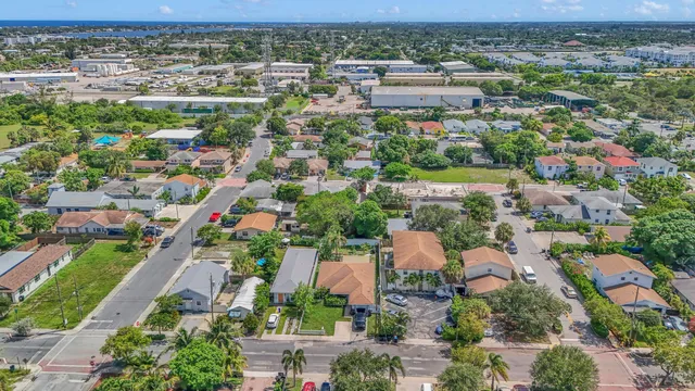 an aerial view of residential houses with outdoor space and trees