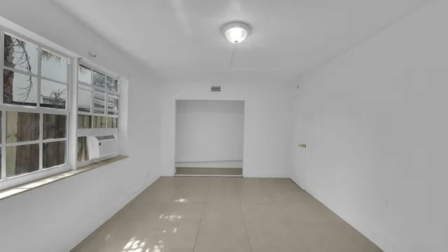 an empty room with windows and closet