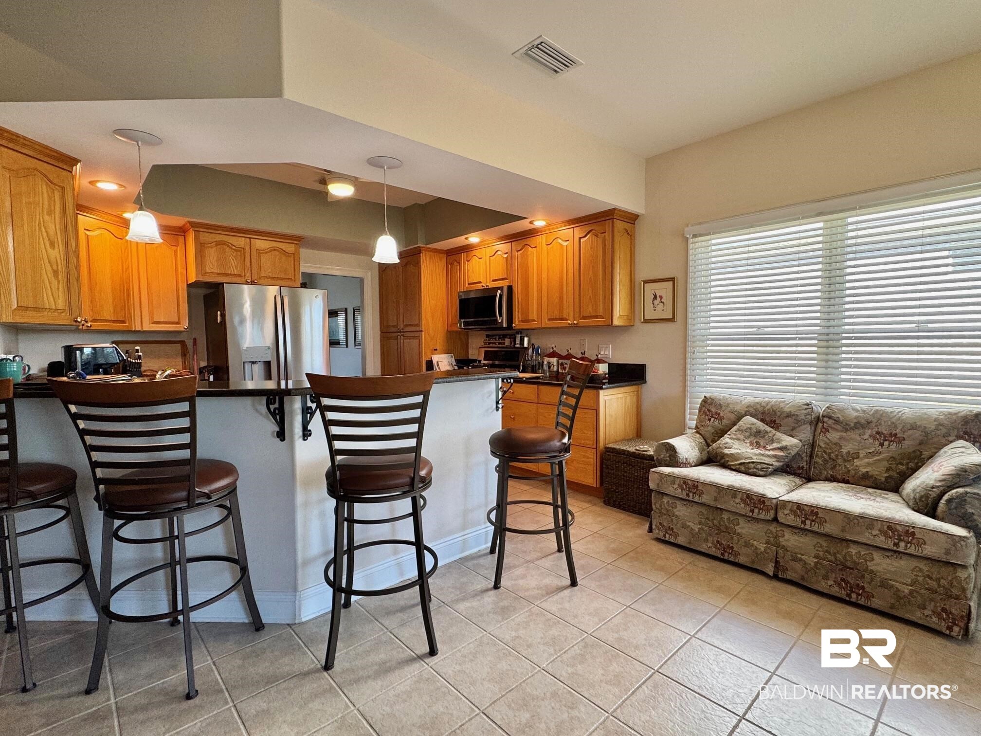 22415 Inverness Way Foley, AL 36535 - Photo 8 of 34 Kitchen featuring kitchen peninsula, a breakfast bar, stainless steel appliances, light tile patterned floors, and decorative light fixtures