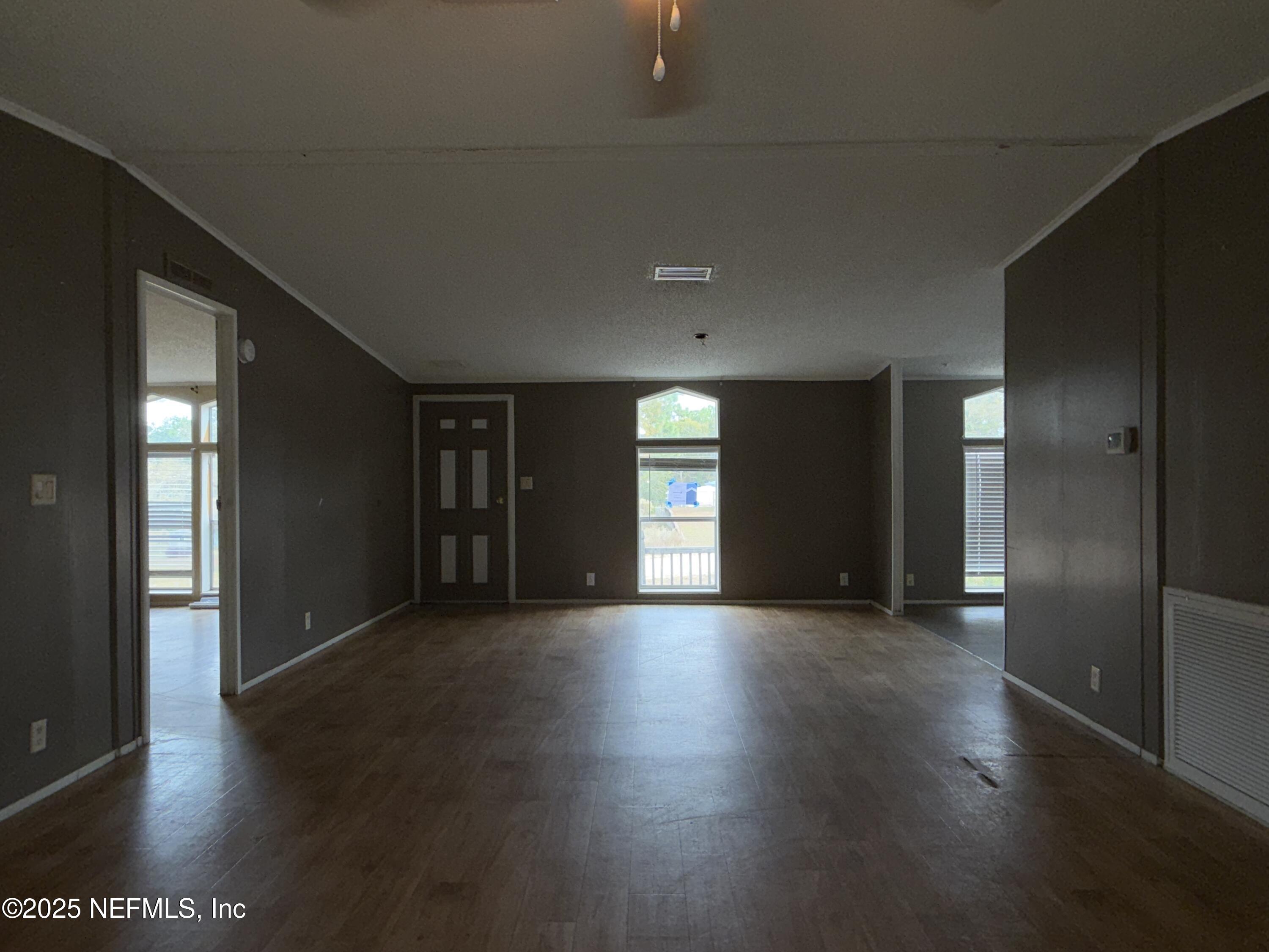 323 Incline Road Satsuma, FL 32189 - Photo 9 of 12 an empty room with wooden floor and windows