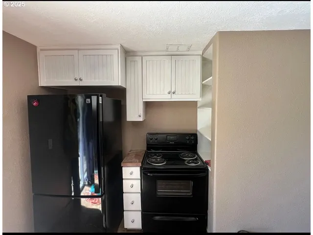 a kitchen with a refrigerator and cabinets