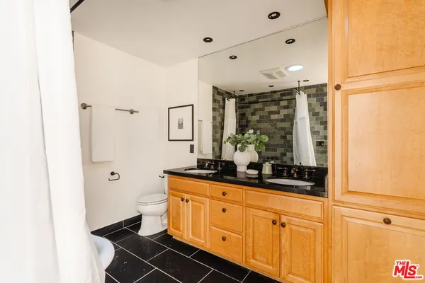 a bathroom with a double vanity sink a mirror and shower
