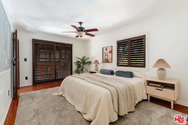 a bedroom with a bed next to a window and a chandelier