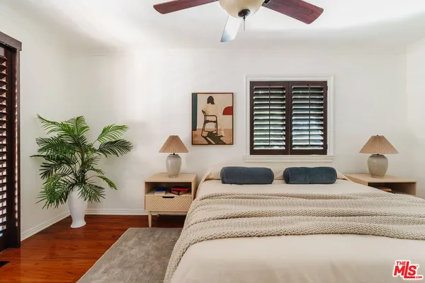 a bedroom with a large bed and a potted plant
