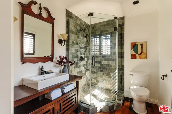 a bathroom with a sink toilet a mirror and shower