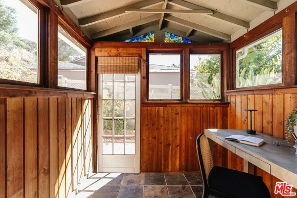 a view of a porch with a table and chairs under an umbrella