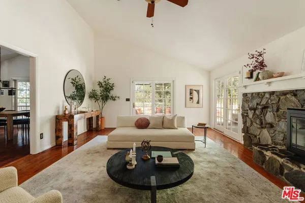 a living room with furniture a fireplace and gym equipment
