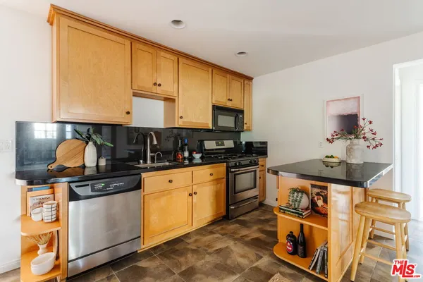 a kitchen with stainless steel appliances granite countertop a stove and cabinets