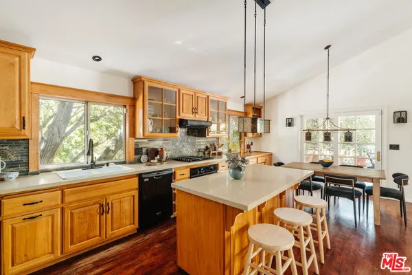 a open kitchen with stainless steel appliances granite countertop a refrigerator a sink dishwasher a stove and white countertops with wooden floor