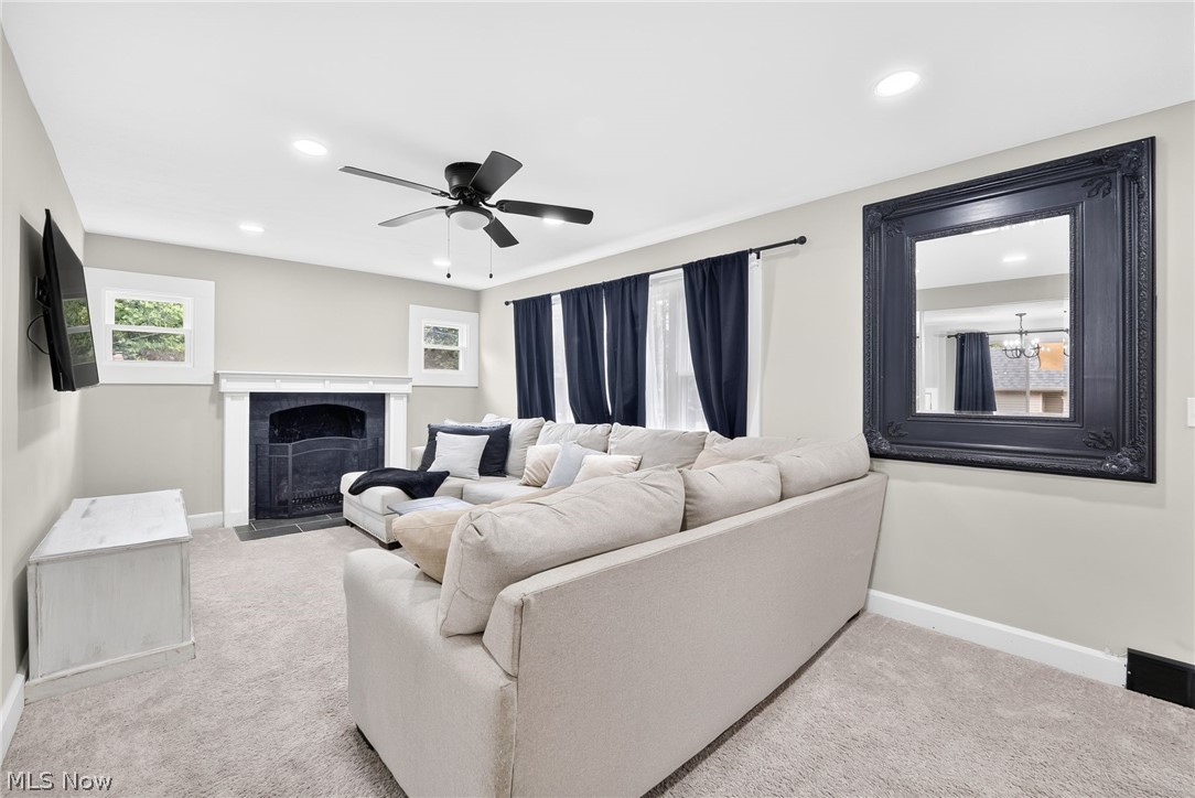 4824 Manchester Road Akron, OH 44319 - Photo 11 of 39 Living area featuring a central fireplace with white mantel, recessed lighting, and a ceiling fan