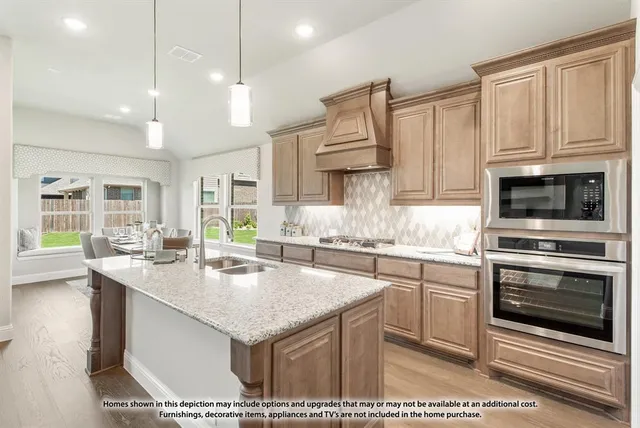 a kitchen with stainless steel appliances granite countertop a stove a sink and a microwave