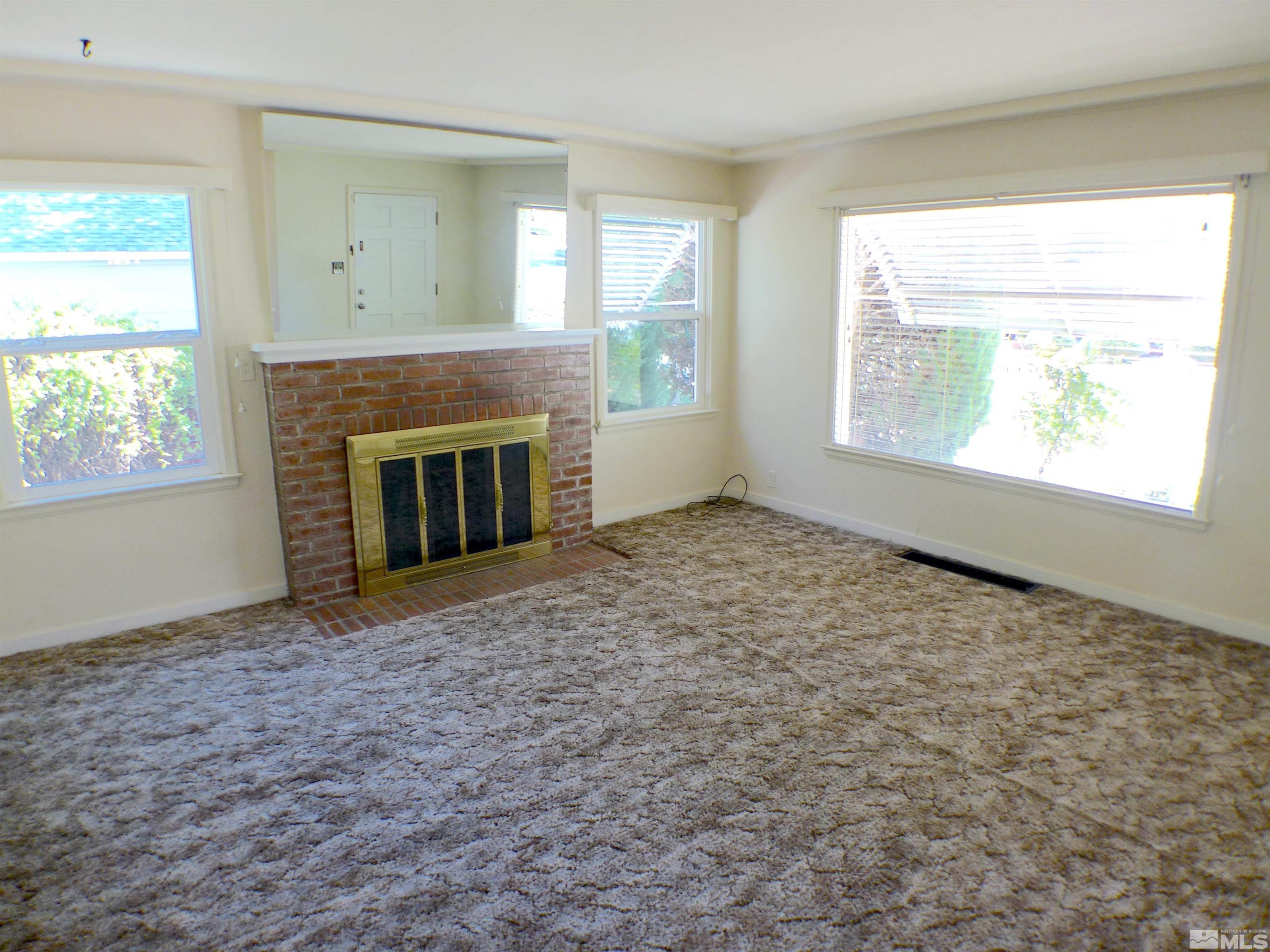 1285 Tacoma Way Reno, NV 89509 - Photo 3 of 10 an empty room with windows and fireplace