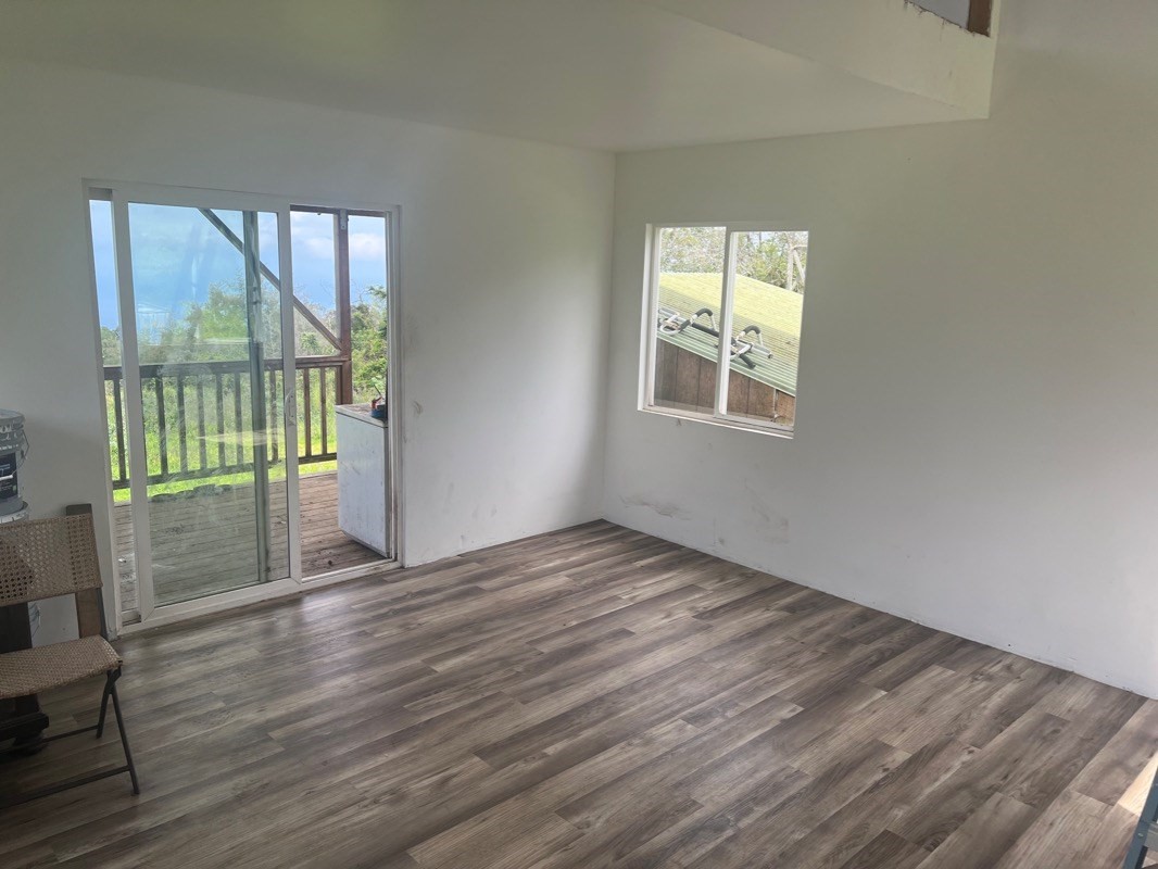 81-1084 Lot F-32 Captain Cook Road Captain Cook, HI 96704 - Photo 6 of 15 a view of an empty room with wooden floor and a window