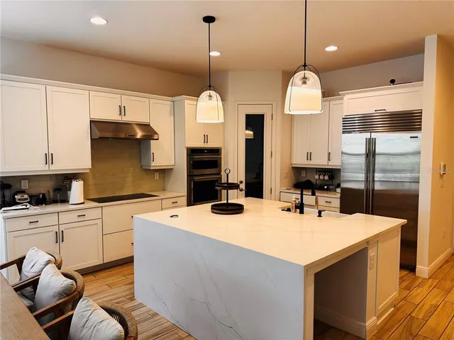 a kitchen with stainless steel appliances kitchen island granite countertop a sink and cabinets
