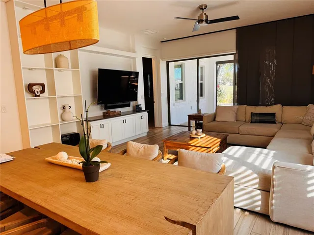 a living room with patio furniture and a flat screen tv