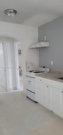 a kitchen with granite countertop white cabinets and stainless steel appliances