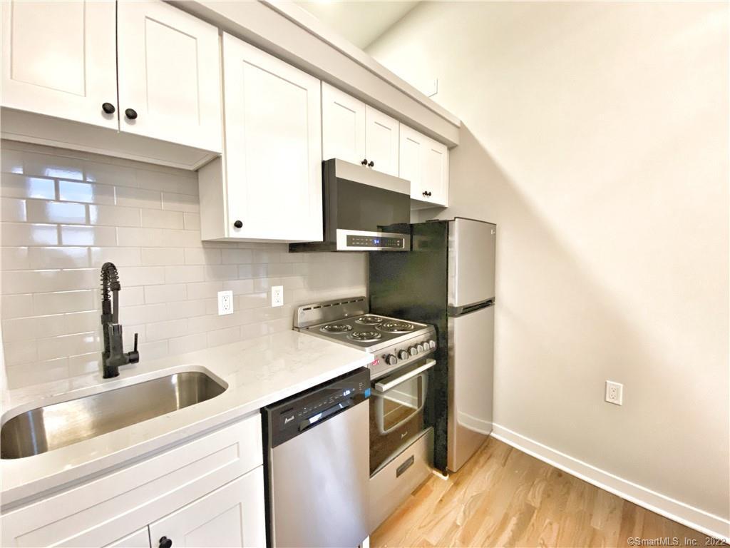 39 Wall Street, Unit 11 Norwalk, CT 06850 - Photo 1 of 1 a kitchen with a sink cabinets and a wooden floor