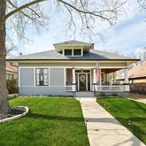 a front view of a house with a yard and trees