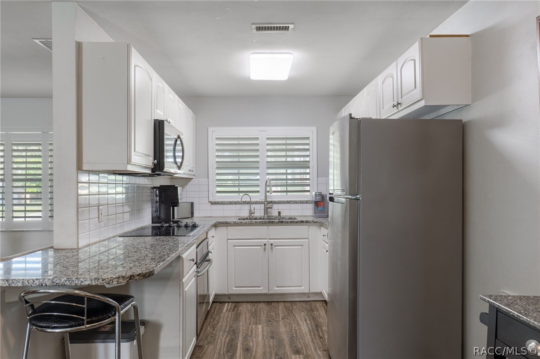 1140 South Highlands Avenue Inverness, FL 34452 - Photo 16 of 54 a kitchen with granite countertop a sink stove and refrigerator