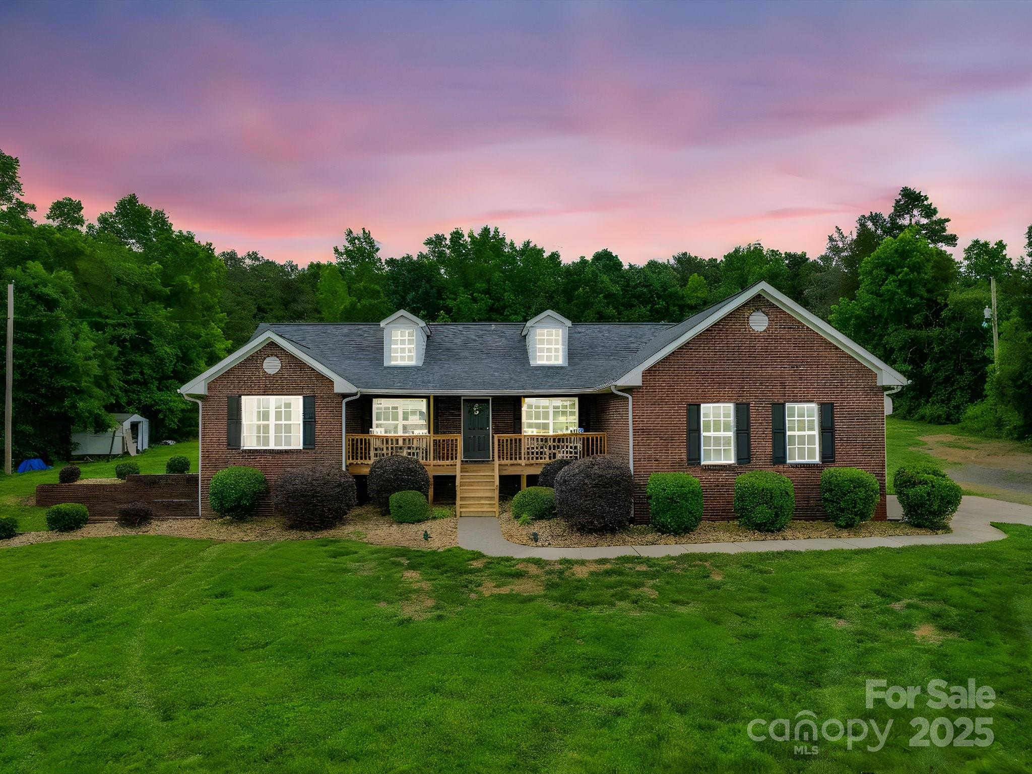 a front view of a house with a yard and green space