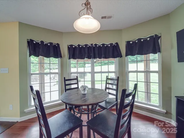 a view of a dining room with furniture a chandelier and wooden floor