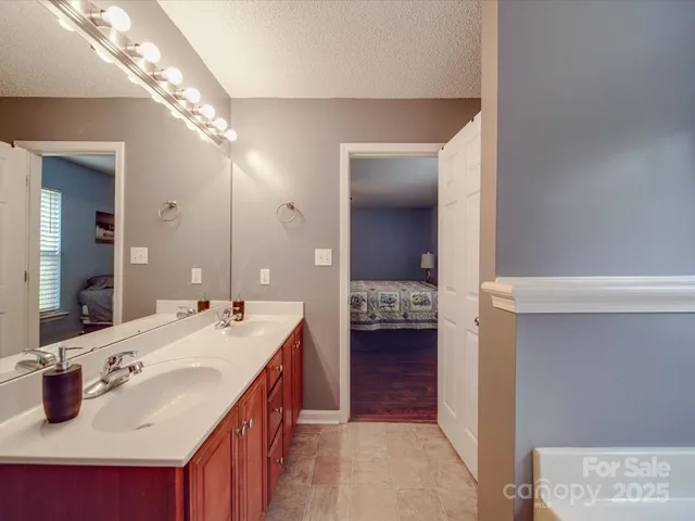 a en suite bathroom with a sink double vanity and shower