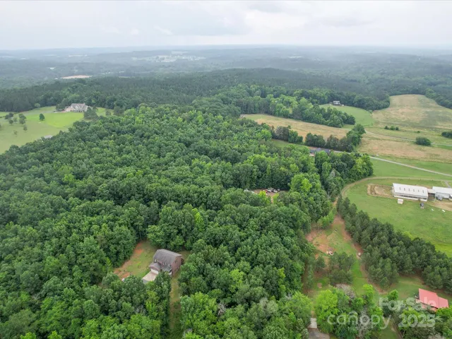 an aerial view of residential houses with outdoor space and trees