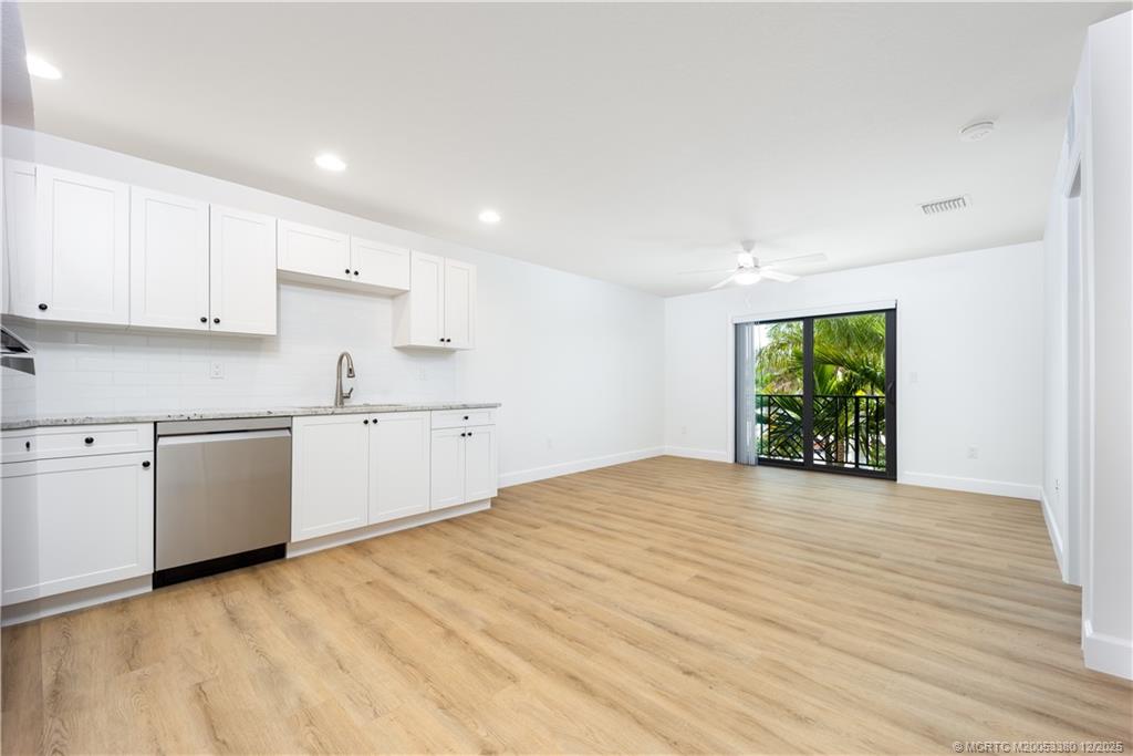a view of a kitchen with wooden floor and electronic appliances