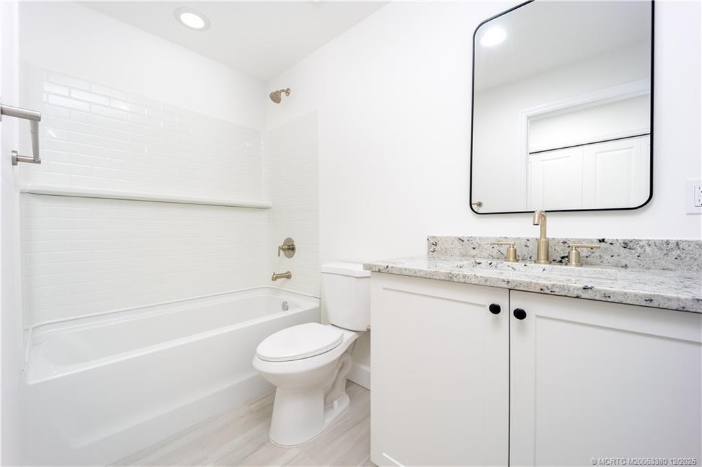 3375 Southwest Mapp Road, Unit 206 Palm City, FL 34990 - Photo 12 of 34 a bathroom with a granite countertop toilet sink and mirror