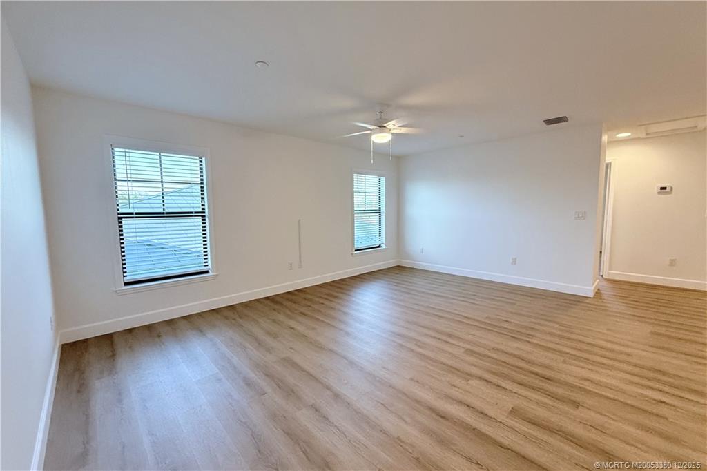 3375 Southwest Mapp Road, Unit 206 Palm City, FL 34990 - Photo 28 of 34 an empty room with wooden floor and windows