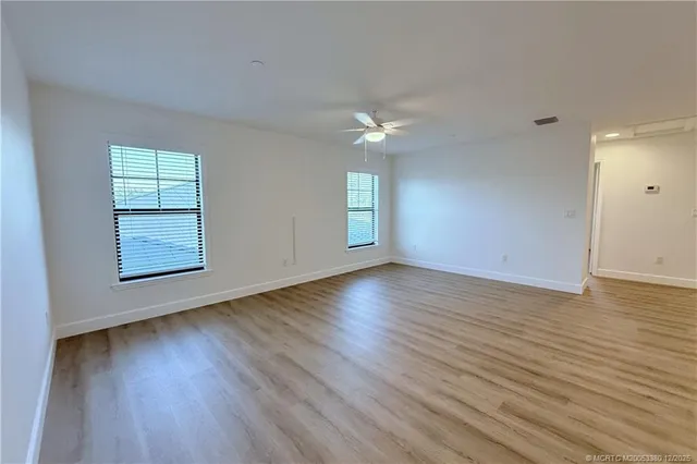 a kitchen with stainless steel appliances a refrigerator and a wooden floor