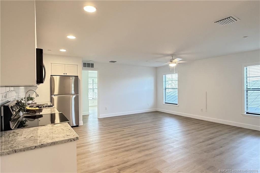 3375 Southwest Mapp Road, Unit 206 Palm City, FL 34990 - Photo 4 of 34 a view of a kitchen with refrigerator and wooden floor