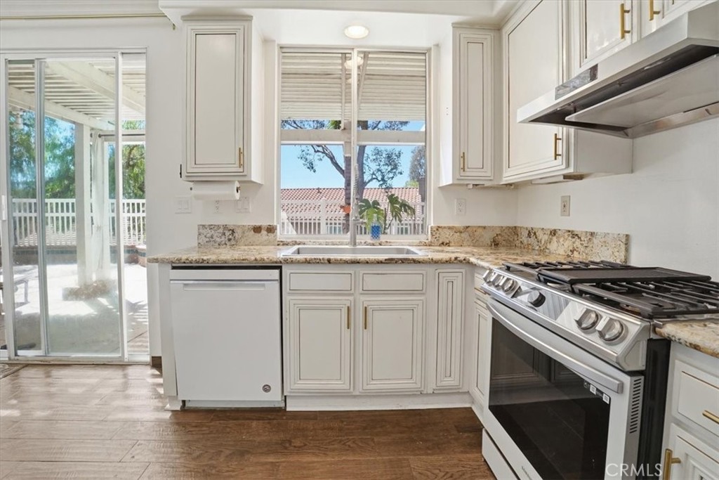 768 Ochee Circle Corona, CA 92879 - Photo 30 of 75 a kitchen with stainless steel appliances granite countertop a stove a sink and a microwave