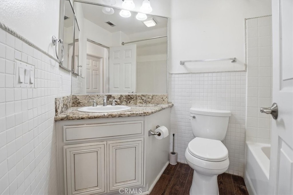 768 Ochee Circle Corona, CA 92879 - Photo 52 of 75 a bathroom with a granite countertop toilet sink and mirror