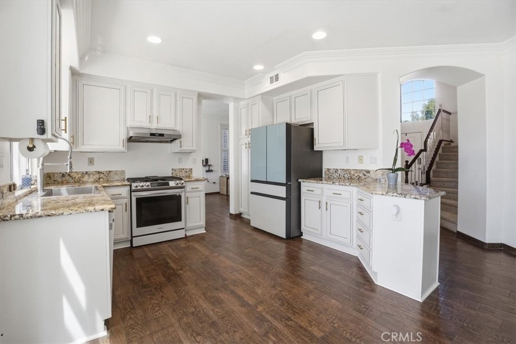 768 Ochee Circle Corona, CA 92879 - Photo 10 of 75 a kitchen with white cabinets and stainless steel appliances