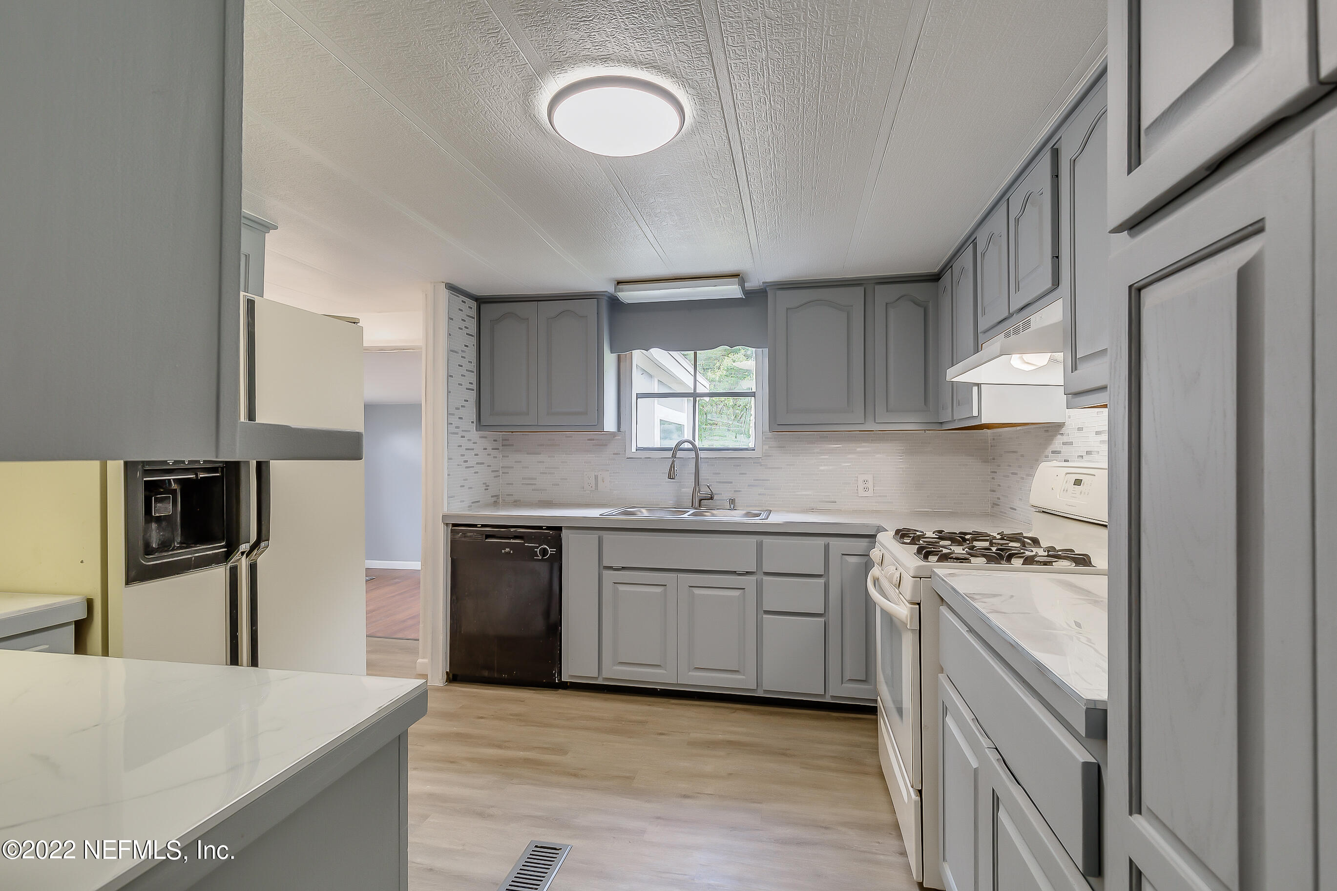 54360 Church Road Callahan, FL 32011 - Photo 2 of 37 a kitchen with stainless steel appliances granite countertop a stove a sink dishwasher and a refrigerator