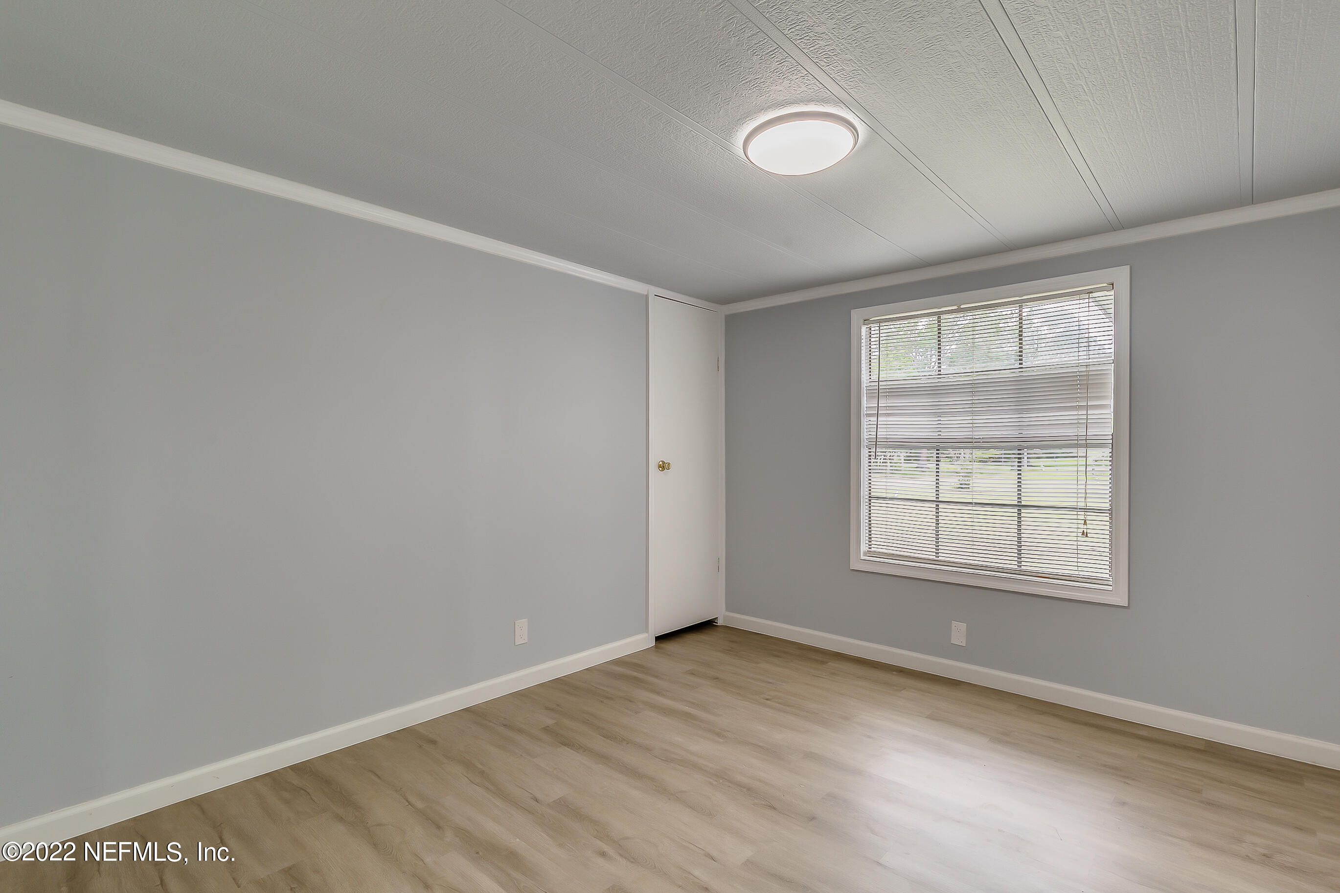 54360 Church Road Callahan, FL 32011 - Photo 31 of 37 an empty room with wooden floor and windows